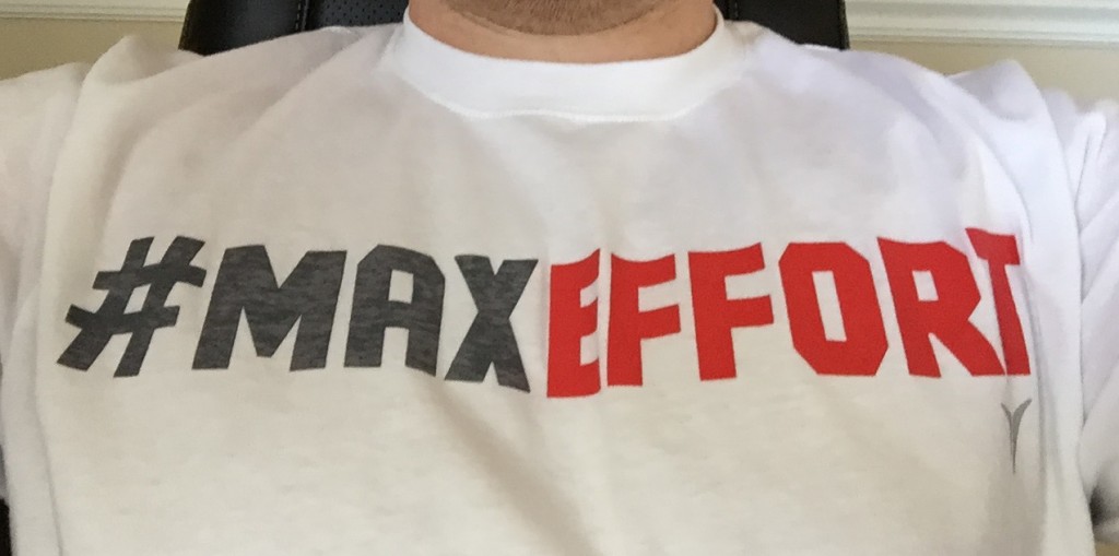 White T-shirt printed with “#MAXEFFORT” in black and red.